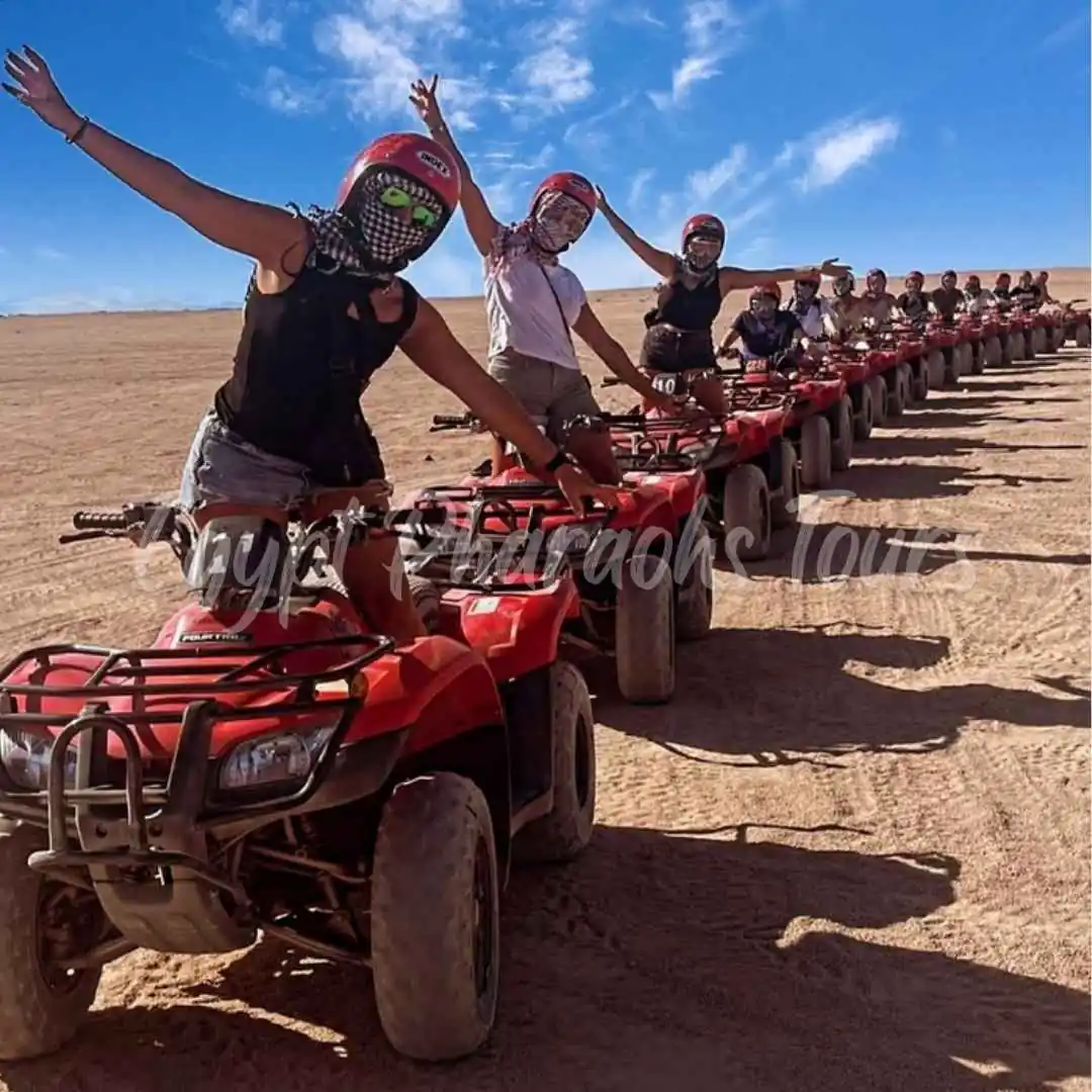 Travelers riding ATV quad bikes through the desert dunes on a Hurghada safari tour
